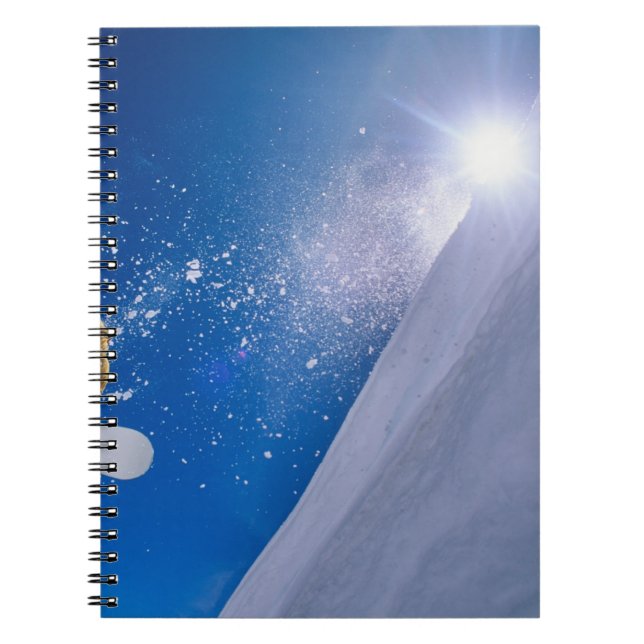 Man flying through the air on a snowboard with notebook (Front)