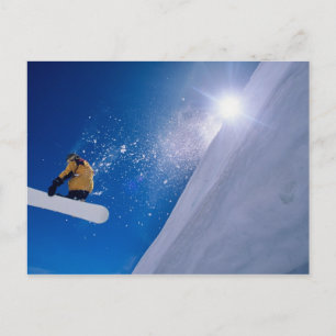 Man flying through the air on a snowboard with postcard