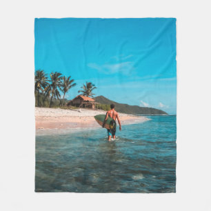 Man holding surf board in body of water fleece blanket