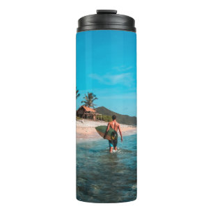 Man holding surf board in body of water thermal tumbler