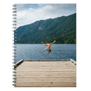 Man jumping near sea notebook