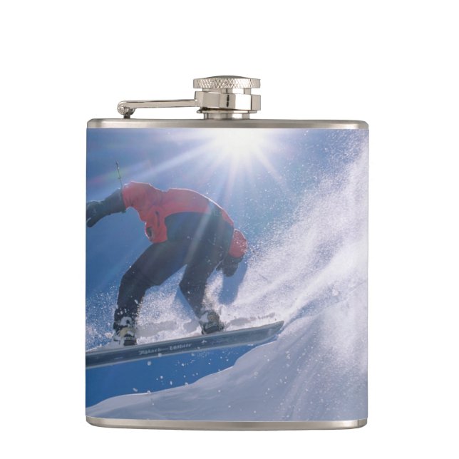 Man jumping off a large cornince on a snowboard hip flask (Front)