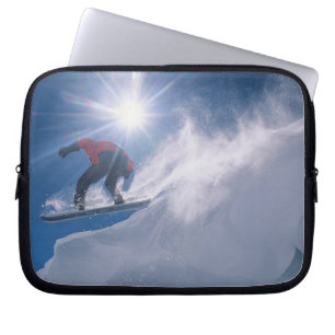 Man jumping off a large cornince on a snowboard laptop sleeve