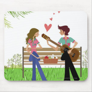 Man playing the guitar with a woman beside her mouse pad