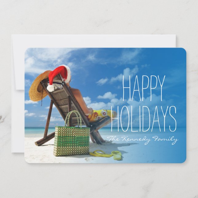 Man relaxing on the beach in santa's hat holiday card (Front)