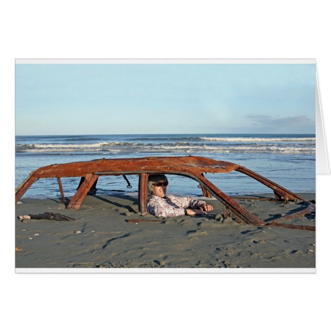 Man sitting in rusty car on beach (Front Horizontal)