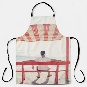 Man sitting on bench near beach apron