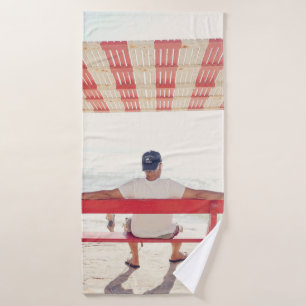 Man sitting on bench near beach bath towel