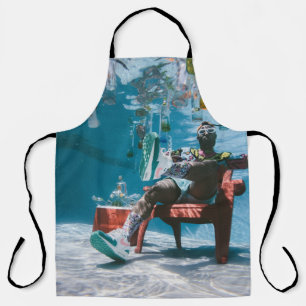 Man sitting on chair underwater with floating bott apron