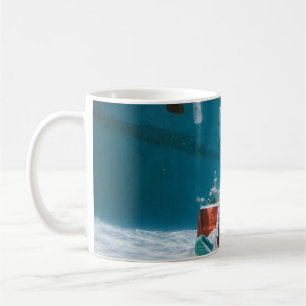 Man sitting on chair underwater with floating bott coffee mug