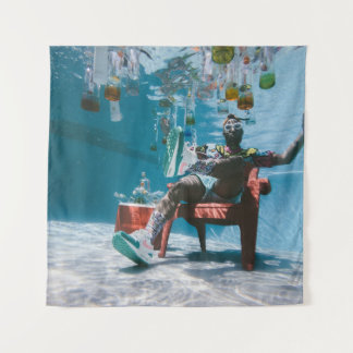 Man sitting on chair underwater with floating bott tapestry