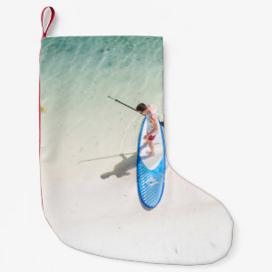 Man surfing on beach small christmas stocking