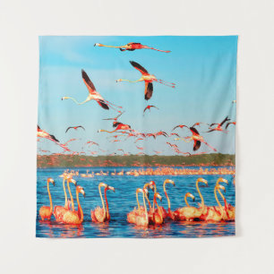 Many pink beautiful flamingos in a beautiful blue tapestry