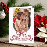 Merry Christmas Simple Modern Coquette Bow Photo Holiday Card<br><div class="desc">Merry Christmas Simple Modern Coquette Bow Photo Folded Holiday Card Christmas Cards features a simple design with your favourite photo with the text overlay "Merry Christmas" in modern calligraphy script typography accented with a trendy red bow on a white background. Personalised your names or custom text below and your custom...</div>