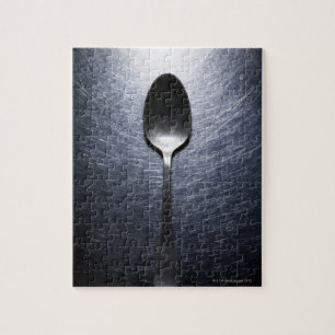 Metal spoon on stainless steel jigsaw puzzle