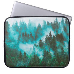Misty foggy mountain landscape with fir forest and laptop sleeve