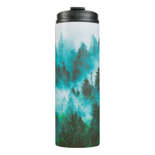 Misty foggy mountain landscape with fir forest and thermal tumbler