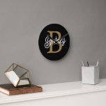 Modern Elegant Monogram Name Black Gold Script Round Clock<br><div class="desc">The Modern Elegant Monogram Name Black Gold Script Clock is a stylish and personalised timepiece perfect for any home or office setting. This clock features a sleek black face with elegant gold script, allowing you to customise it with your monogram and name. The modern design and sophisticated colour scheme make...</div>