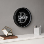 Modern Elegant Monogram Name Black Grey Script Clock<br><div class="desc">The Modern Elegant Monogram Name Black Grey Script Clock is a sophisticated addition to any space, blending functionality with style. Featuring a sleek black face with grey script, this clock is personalised with an elegant monogram and name, making it a unique and refined timepiece. Ideal for home or office settings,...</div>