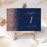 Modern Navy Blue Rose Gold Glitter Wedding Table Number<br><div class="desc">The left-hand edge of this elegant modern wedding table number features a rose gold faux glitter design. The customisable text combines rose pink handwriting,  copperplate and italic fonts on a navy blue background.</div>