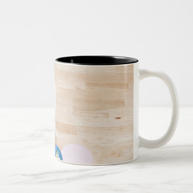 mongrel sitting in front of two bowls with dog Two-Tone coffee mug (Right)
