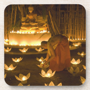 Monks lighting khom loy candles and lanterns for coaster