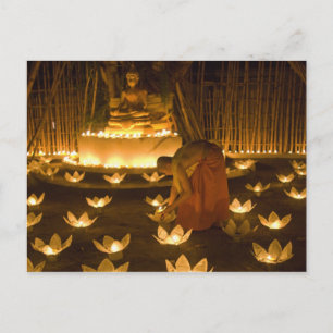 Monks lighting khom loy candles and lanterns for postcard