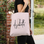 Monogram Blush Pink Tote Bag<br><div class="desc">Make a statement with this stunning monogram black and white tote bag. This stylish bag offers modern, script lettering in an elegant design that will turn heads wherever you go. With plenty of room for your essentials and a unique style, this bag is sure to become a go-to accessory that...</div>