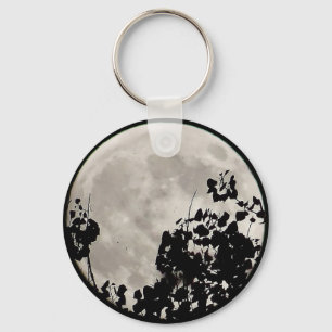 Moon behind dark leaves key ring