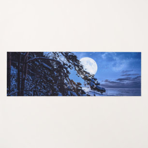Moon over snowy fir tree and sea coast at night yoga mat