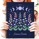 Moonlit Moon Phase Garden 2025 Custom Name Planner<br><div class="desc">Escape to a moonlit garden where dreams bloom under the celestial glow. This enchanting planner, adorned with moon phases and blossoming flowers, invites you to plan your year under the stars. Imagine yourself jotting down your aspirations and appointments amidst this tranquil nocturnal scene. Personalise it with your name and let...</div>