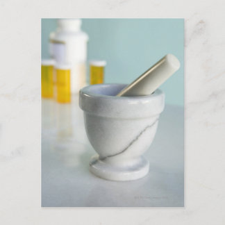 Mortar and pestle, pill bottles in background postcard