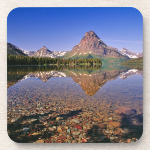 Mountains reflect into calm Two Medicine Lake in Coaster