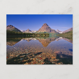 Mountains reflect into calm Two Medicine Lake in Postcard