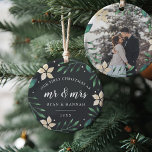 Mr. & Mrs. | First Married Christmas Photo Ceramic Ornament<br><div class="desc">Celebrate your first Christmas as a married couple with this charming and festive ornament. Design features "our first Christmas as Mr. & Mrs." and the year in white lettering, surrounded by ivory poinsettia flowers and green holiday foliage on a dark background. Add a photo to the back with matching holiday...</div>