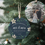 Mr. & Mrs. | First Married Christmas Photo Ceramic Ornament<br><div class="desc">Celebrate your first Christmas as a married couple with this charming and festive ornament. Design features "our first Christmas as Mr. & Mrs." and the year in white lettering, surrounded by ivory poinsettia flowers and green holiday foliage on a rich navy blue background. Add a photo to the back with...</div>