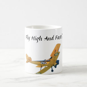 Mug with yellow bi plane. Says "Fly High and Fast"