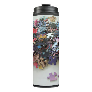 Multi coloured puzzle pieces on a thermal tumbler