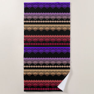 Multicolored lace on black beach towel