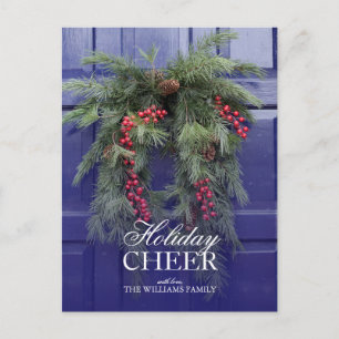 Natural wreath with holly berries on blue door holiday postcard