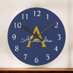 Navy Blue Gold Modern Script Girly Monogram Name Round Clock<br><div class="desc">Navy Blue and Gold Simple Script Monogram Name Clock. This makes the perfect sweet 16 birthday,  wedding,  bridal shower,  anniversary,  baby shower or bachelorette party gift for someone that loves glam luxury and chic styles.</div>