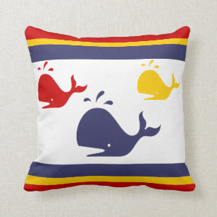 navy blue, yellow, and red whales on white cushion