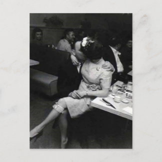 newlyweds kissing at a resturaunt postcard