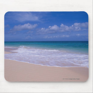 Ocean waves foaming onto sandy beach mouse pad