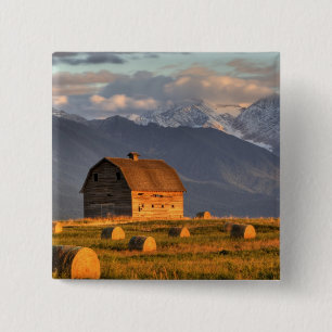 Old barn framed by hay bales and dramatic 15 cm square badge