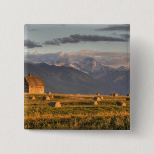 Old barn framed by hay bales and dramatic 15 cm square badge