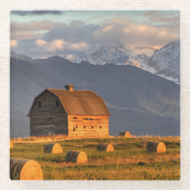 Old barn framed by hay bales and dramatic glass coaster (Front)