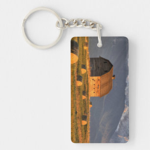 Old barn framed by hay bales and dramatic key ring