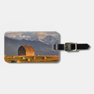 Old barn framed by hay bales and dramatic luggage tag