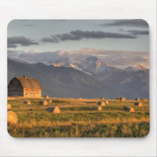 Old barn framed by hay bales and dramatic mouse pad